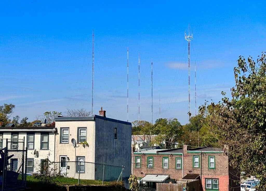 Cluster of radio and television transmission masts above a treeline