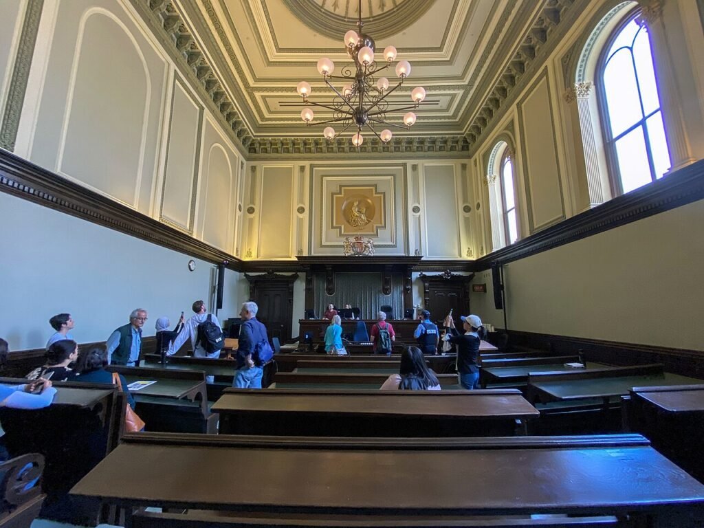 Empty courtroom with wooden benches and the judge's bench at the far end