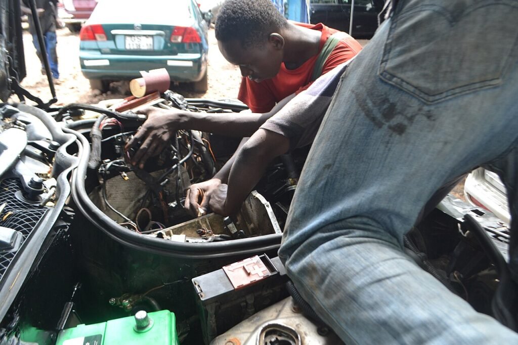 Two mechanics leaning over an open engine bay