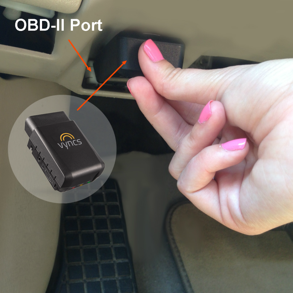 OBD-II GPS tracker being pushed into the diagnostic port under a dashboard